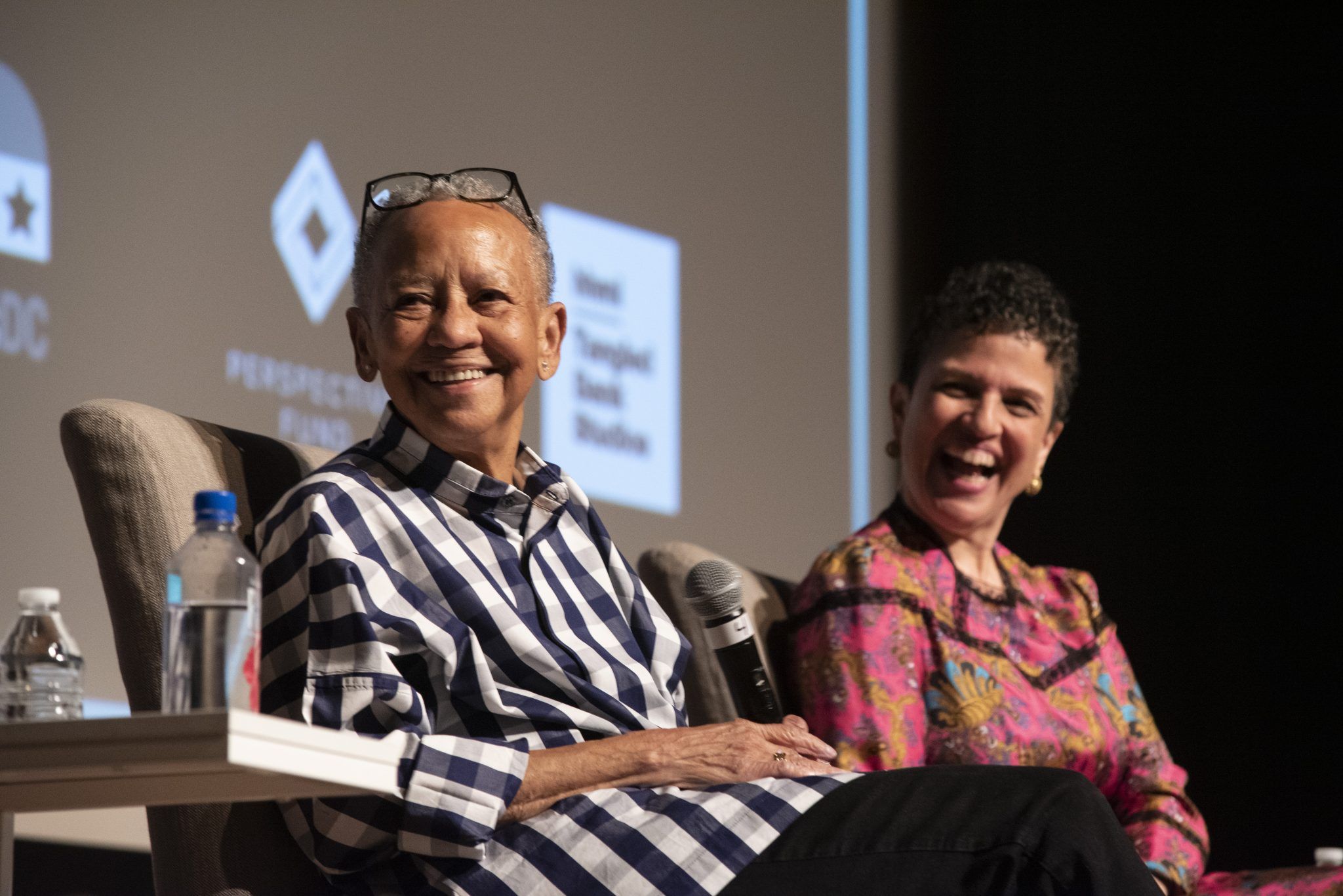 Filmmakers laughing as they answer questions onstage in front of DC/DOX graphics