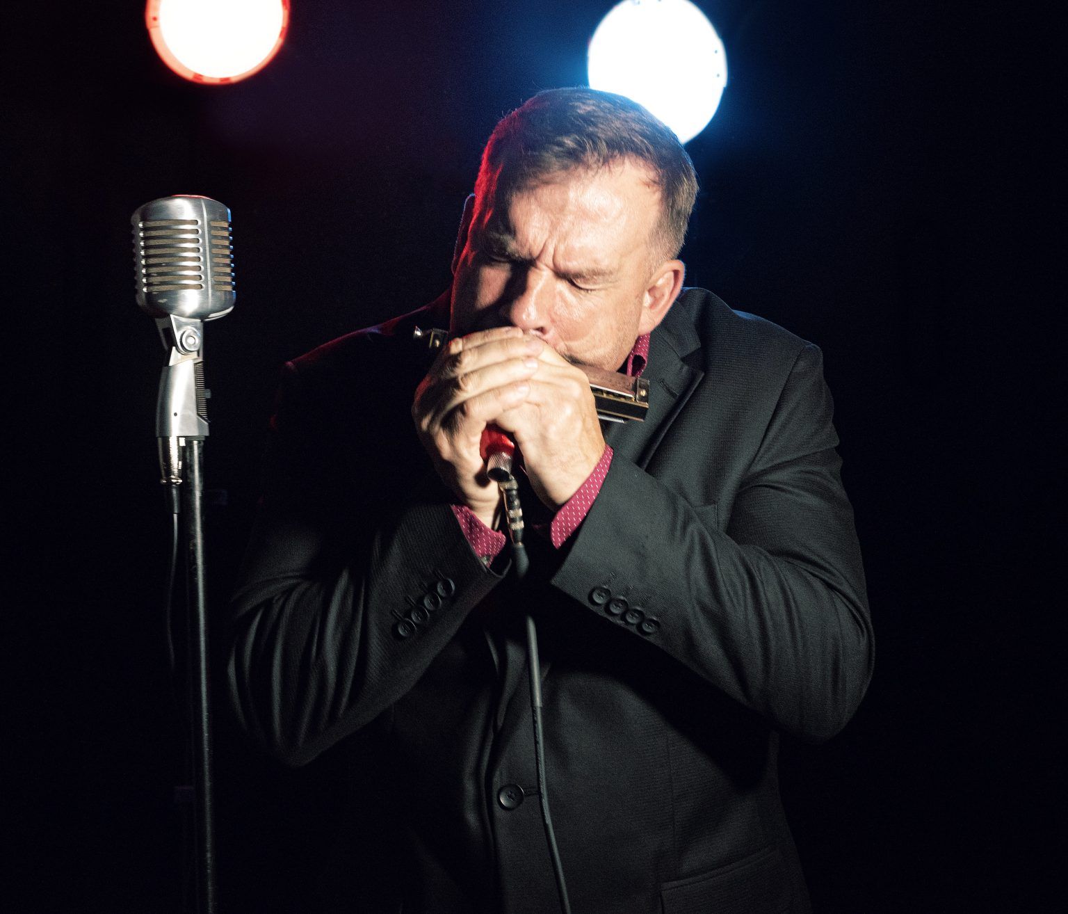 Chris O'Leary plays the harmonica live on stage.