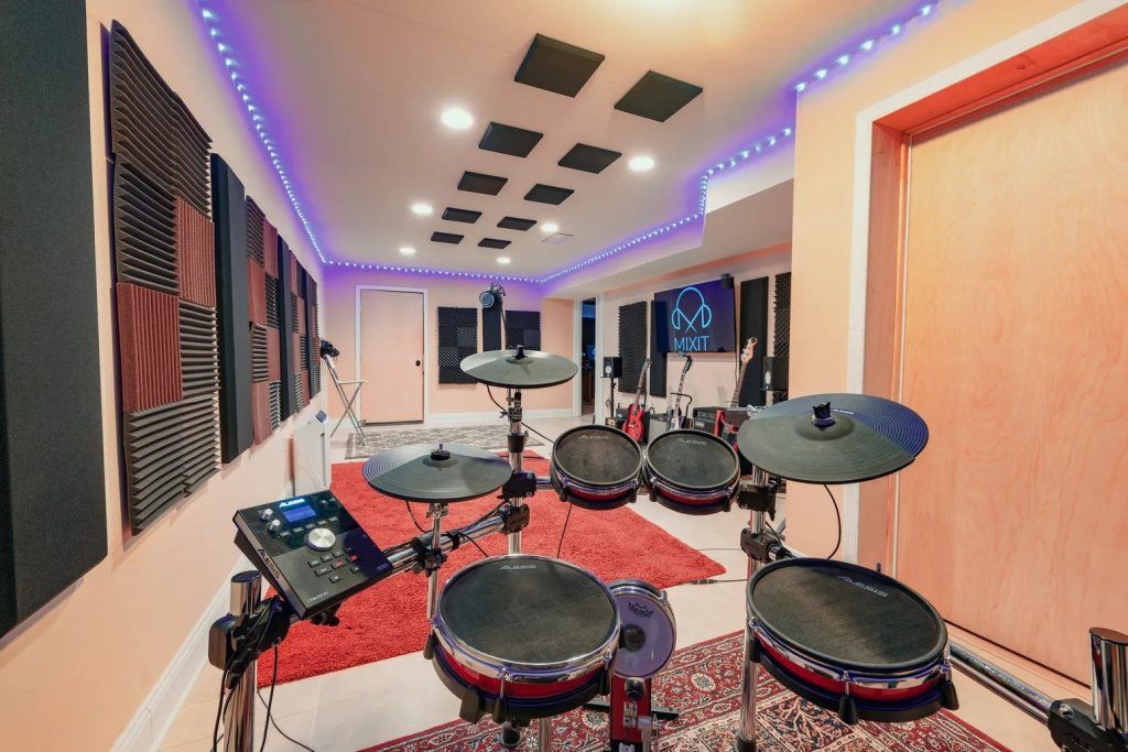 The interior of Mixit Studios featuring an electronic drumse in a brightly lit room with a red carpet.