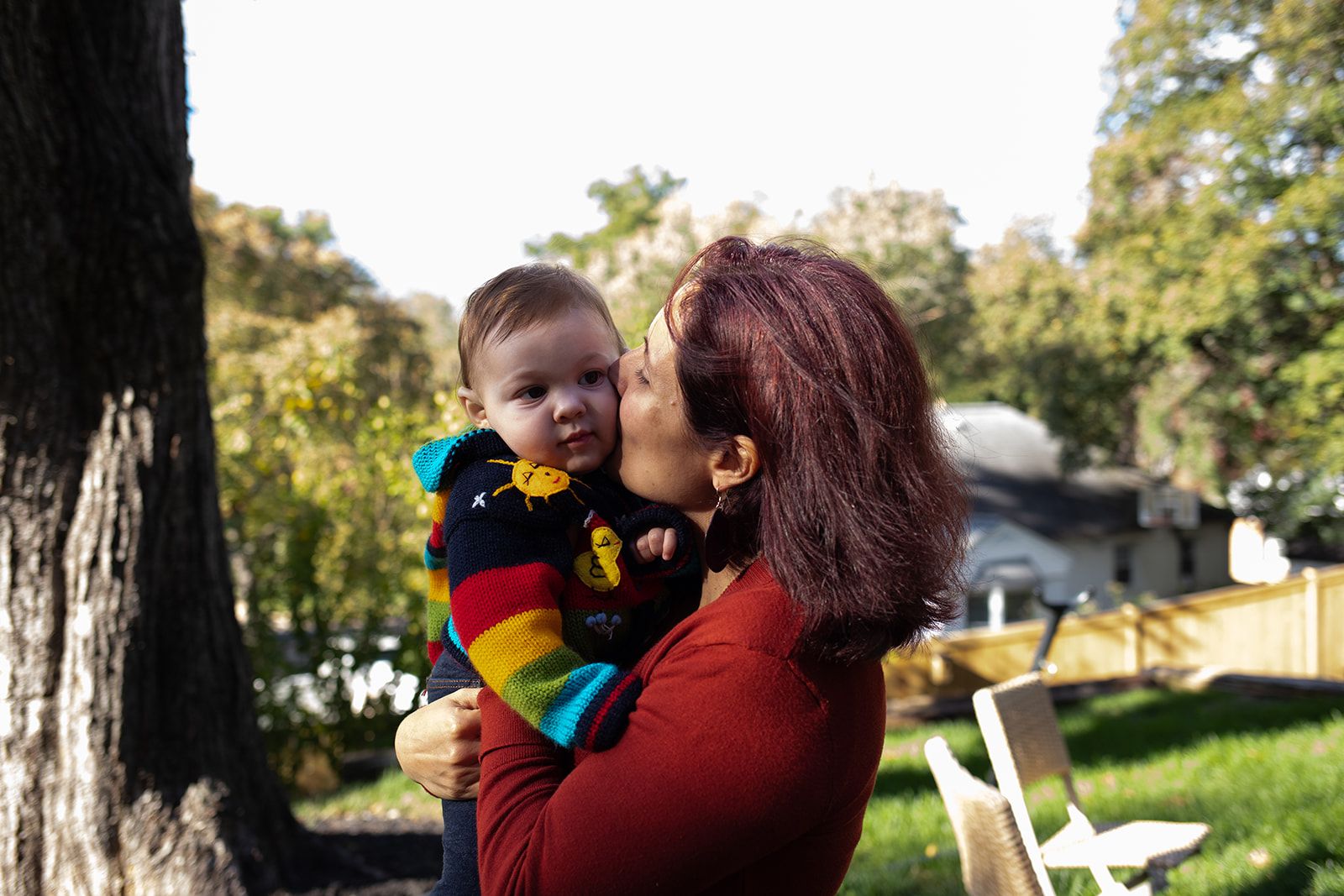 Velu O kisses her 10-month-old son in an outdoor photo.