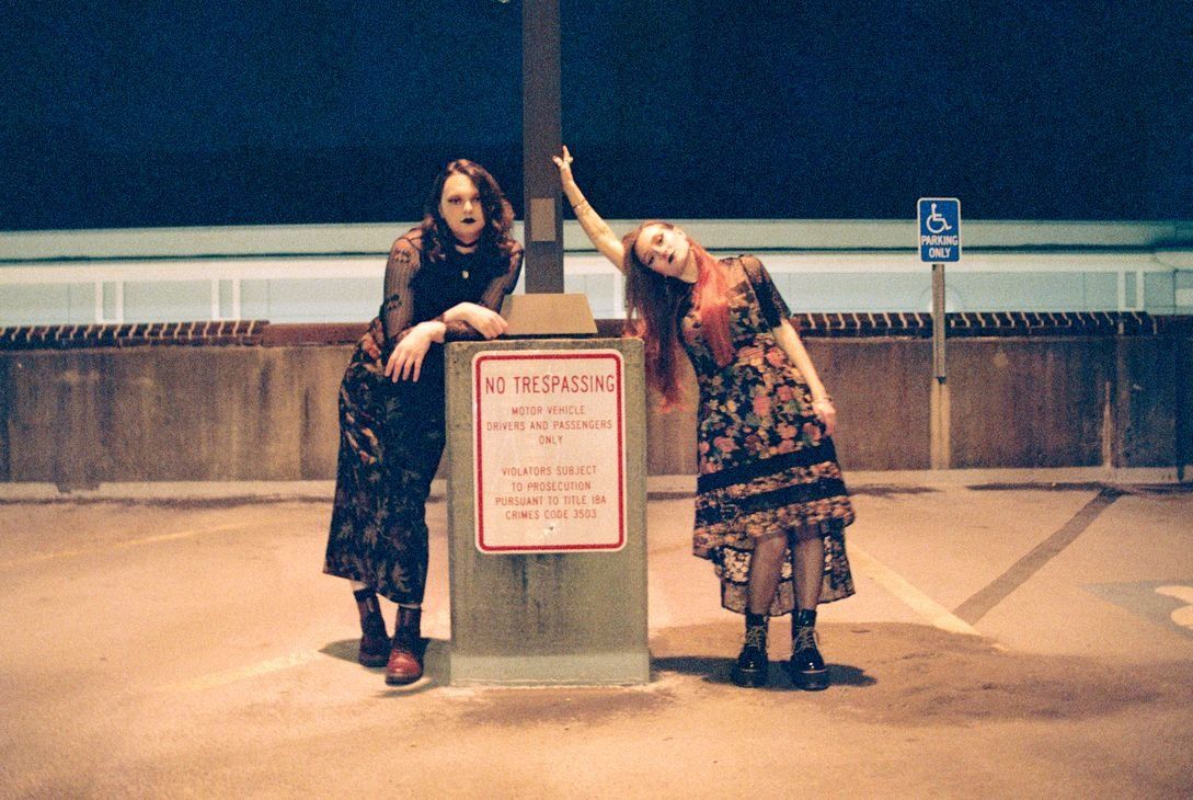 Pennsylvania queer duo Witch Weather pose for a promo photo next to a no trespassing sign.